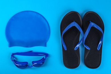 Flat lay composition with swimming accessories on light blue background