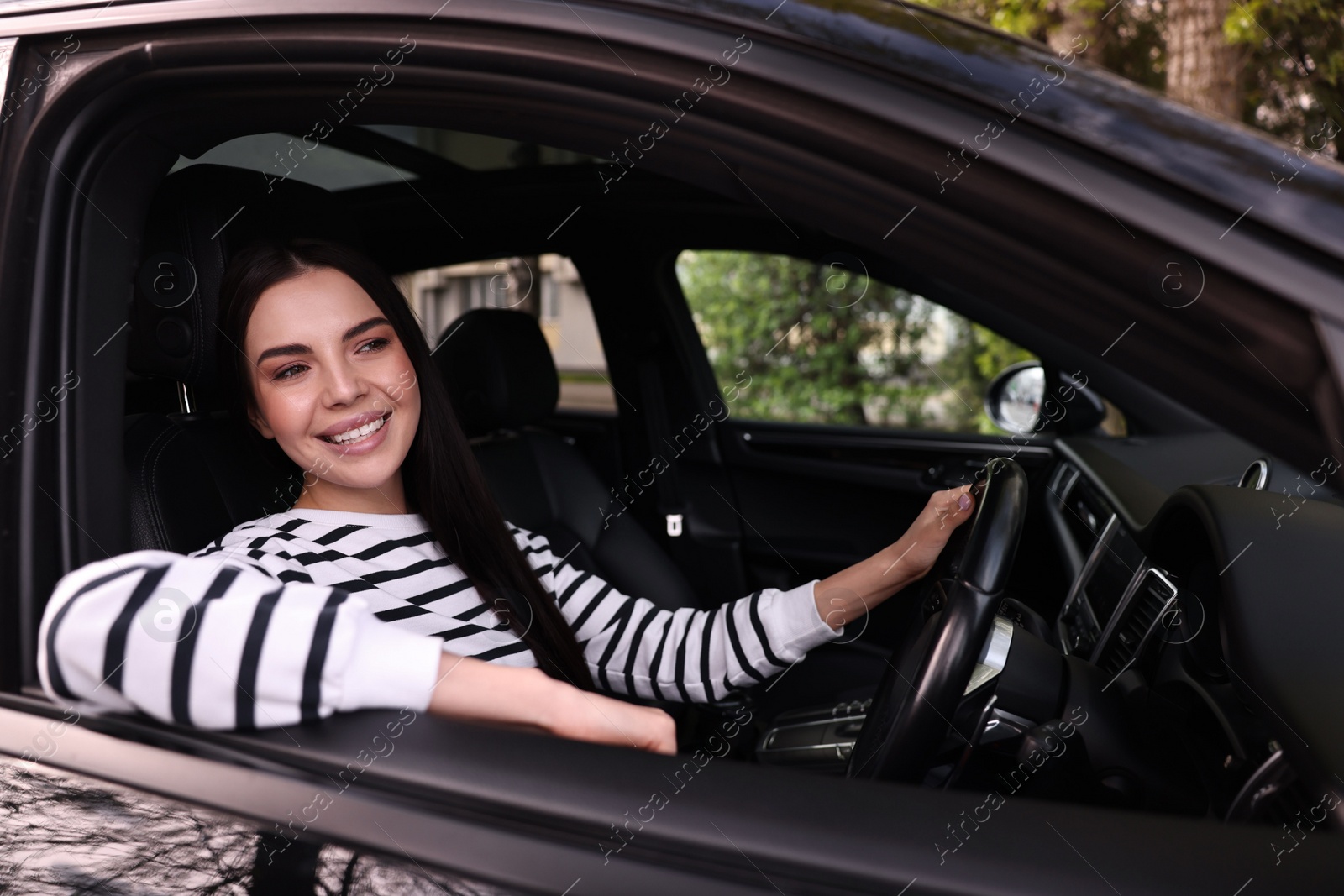 Photo of Young woman sitting inside her modern car