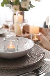 Festive table setting with beautiful tableware and candle, closeup