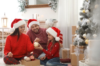Photo of Happy family decorating Christmas tree at home
