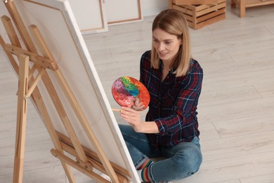 Photo of Beautiful woman painting in studio. Creative hobby
