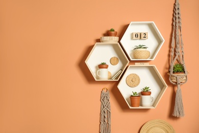 Photo of Shelves with decorative elements on color wall. Space for text