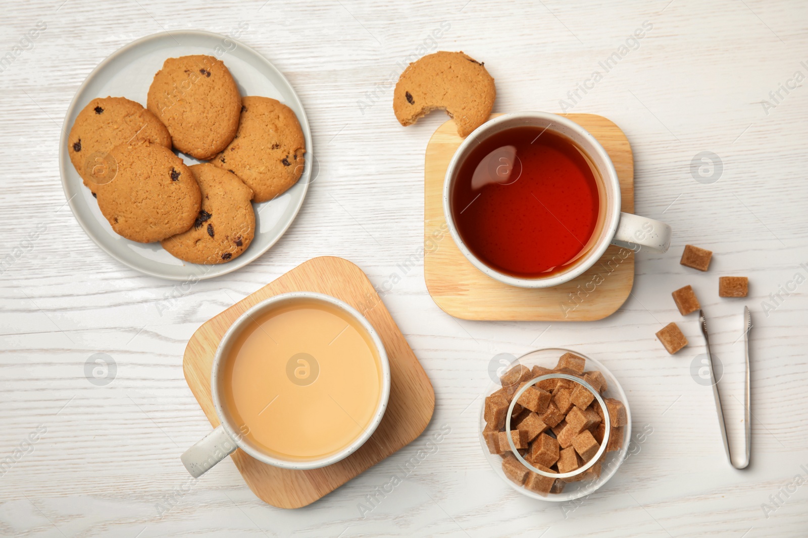 Photo of Flat lay composition with black tea, milk and cookies on wooden table