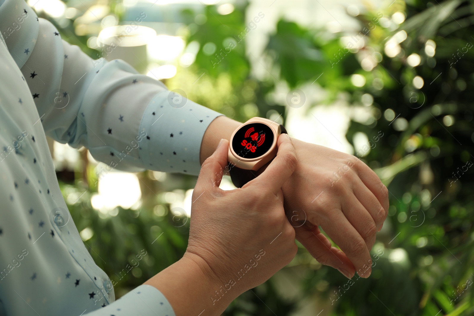 Image of Woman using SOS function on smartwatch outdoors, closeup