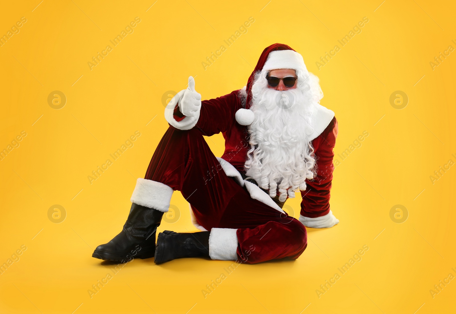 Photo of Santa Claus with sunglasses on yellow background