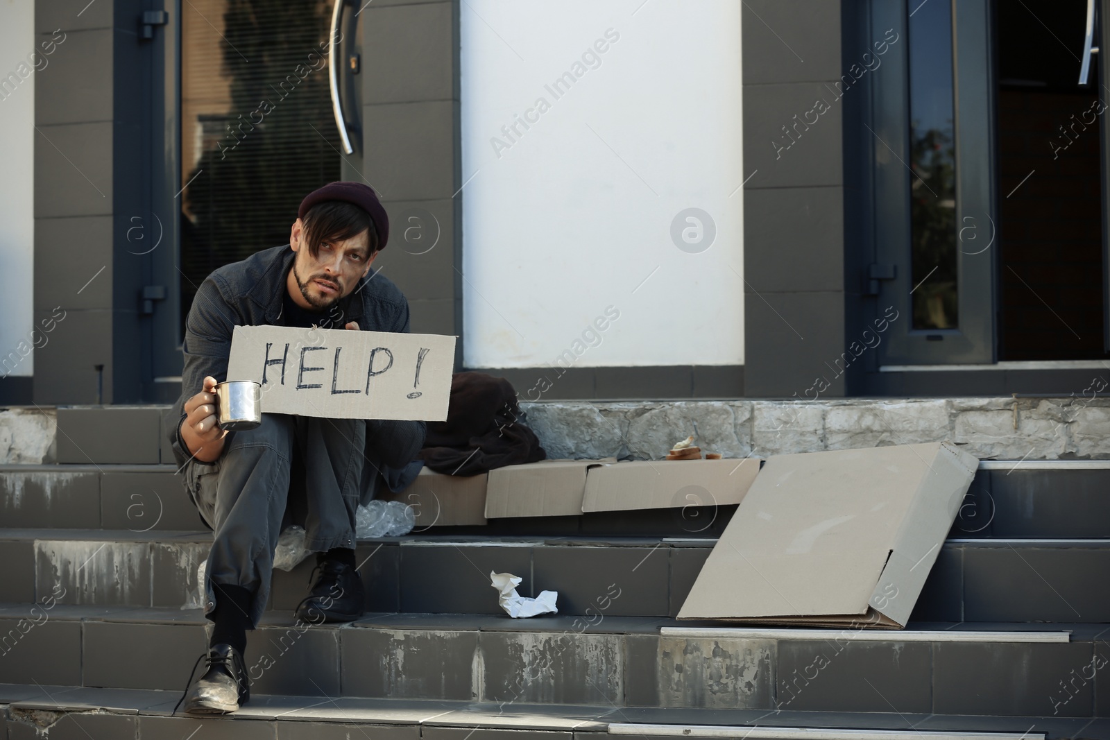 Photo of Poor man with mug begging and asking for help on city street