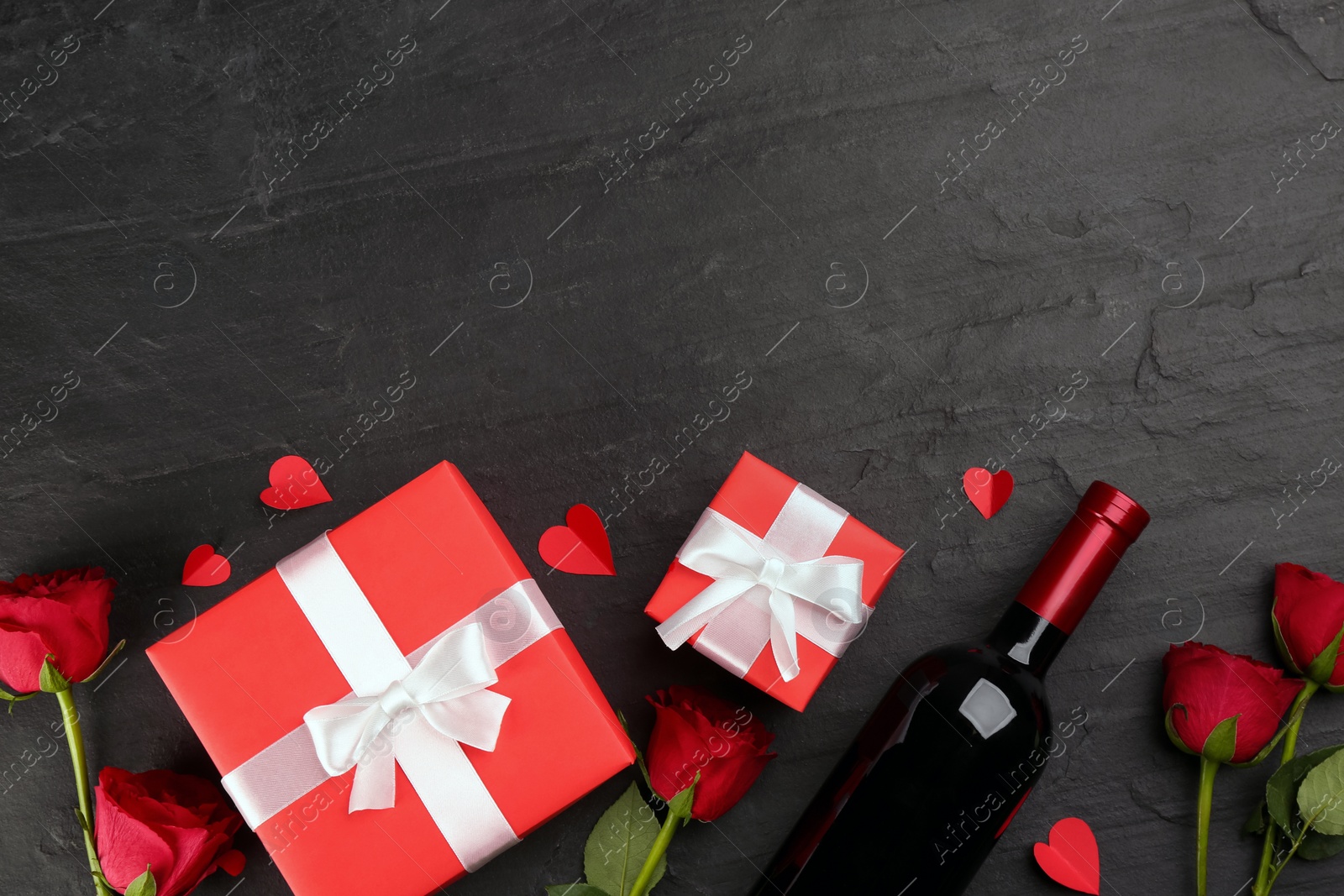 Photo of Flat lay composition with gift boxes and roses on black background, space for text. Valentine's Day celebration