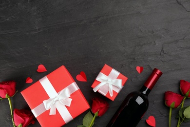 Photo of Flat lay composition with gift boxes and roses on black background, space for text. Valentine's Day celebration