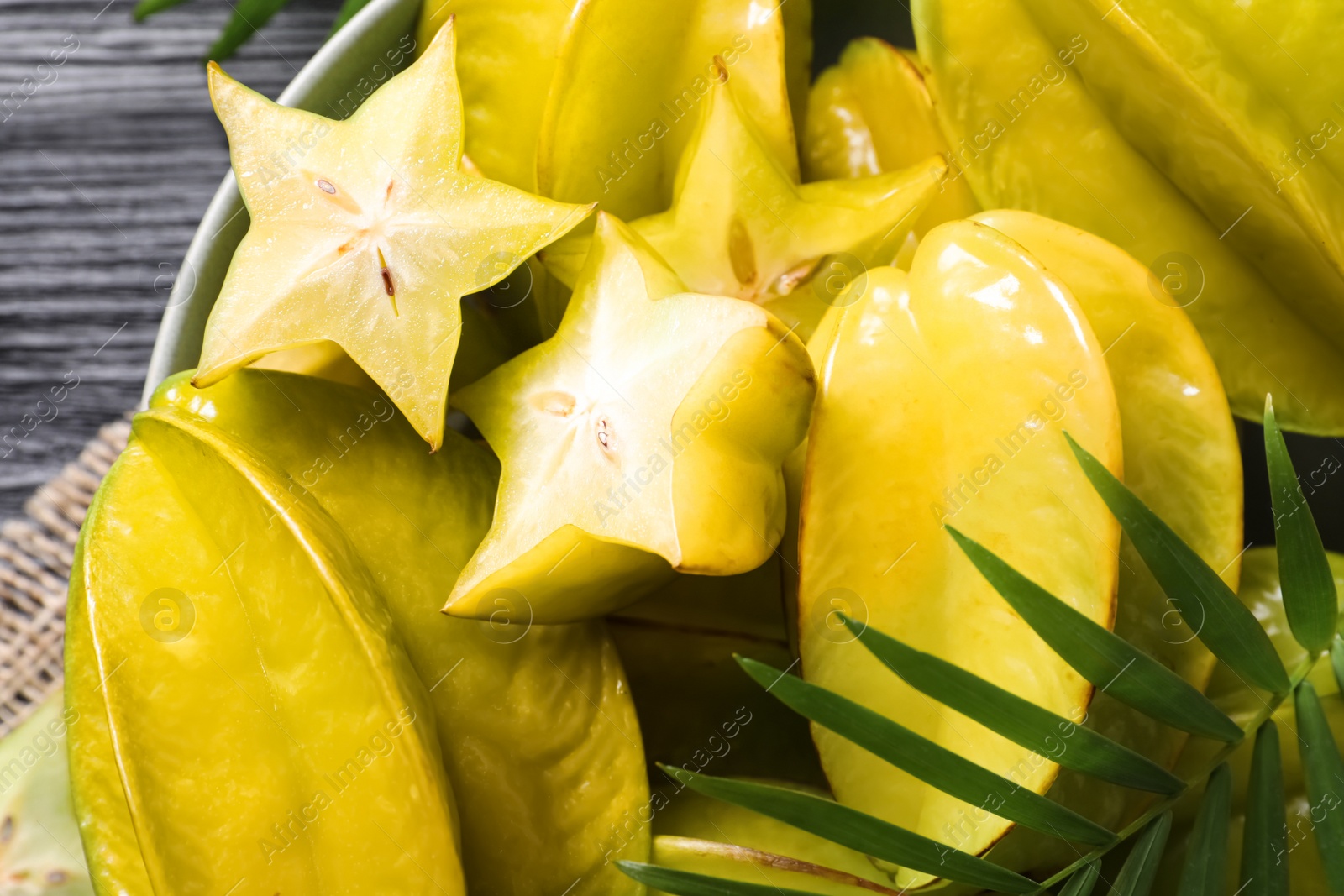 Photo of Delicious carambola fruits on black table, closeup