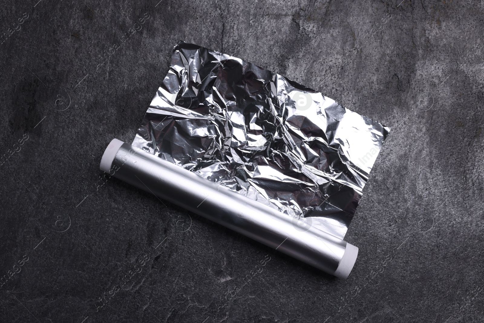 Photo of Roll of aluminum foil on grey table, top view