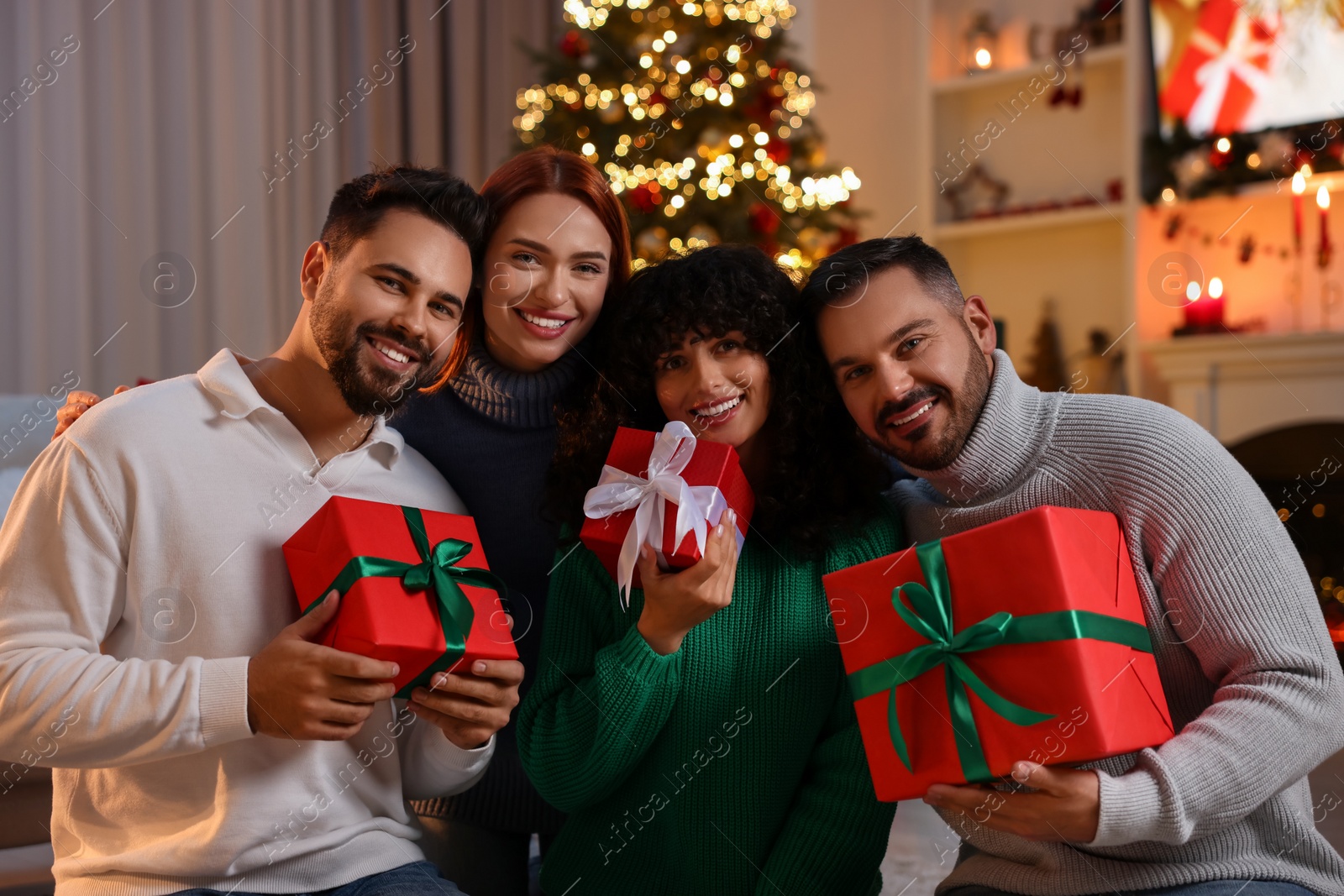 Photo of Christmas celebration. Happy friends with gift boxes at home