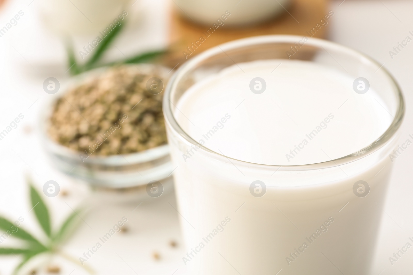 Photo of Composition with glass of hemp milk on white table, closeup. Space for text
