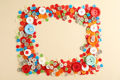 Photo of Frame of colorful sewing buttons on beige background, flat lay. Space for text