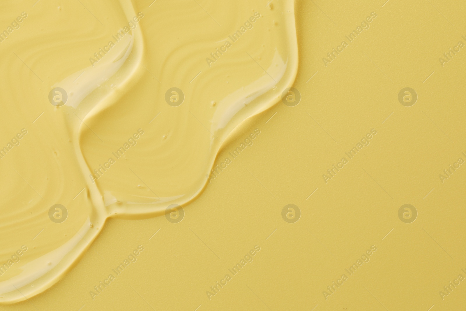 Photo of Clear cosmetic gel on yellow background, top view. Space for text