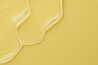 Photo of Clear cosmetic gel on yellow background, top view. Space for text