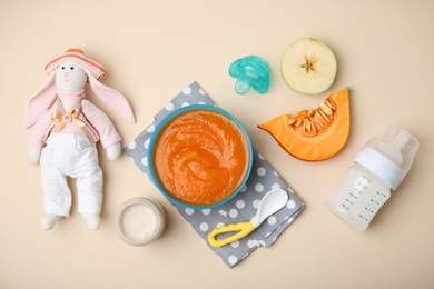 Photo of Flat lay composition with bowl of healthy baby food on color background