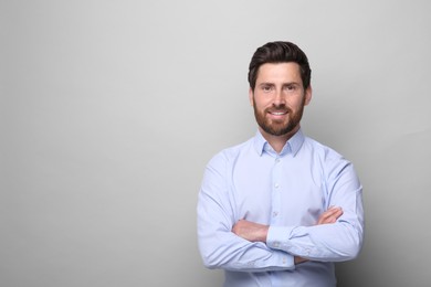 Portrait of handsome man on light grey background, space for text