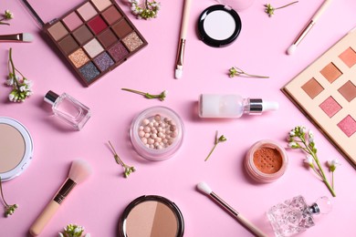 Photo of Flat lay composition with different makeup products and beautiful spring flowers on pink background