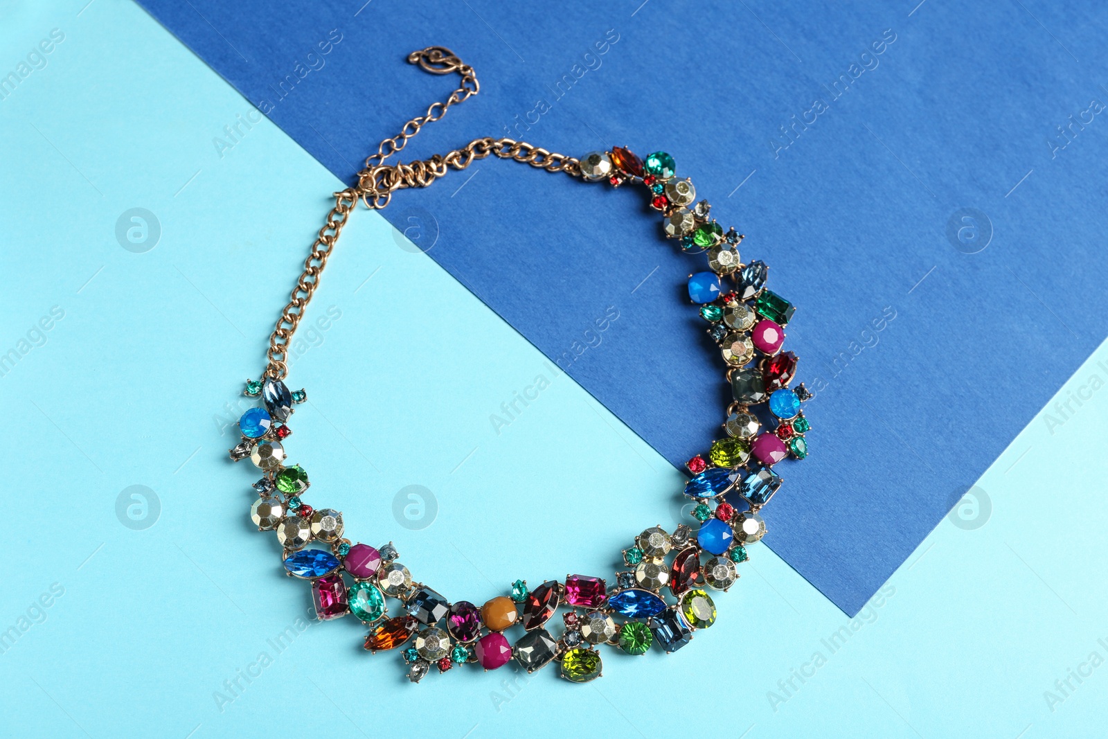 Photo of Elegant necklace on color background, top view. Luxury jewelry