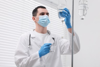 Photo of Doctor setting up IV drip in hospital