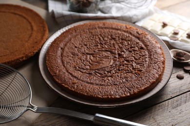 Delicious homemade sponge cake and different kinds of chocolate on wooden table, closeup