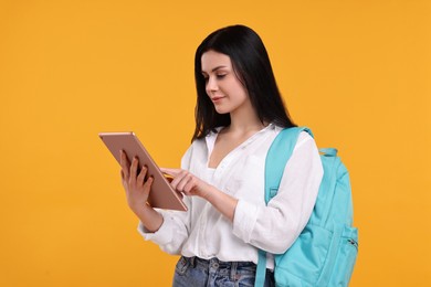 Student with tablet and backpack on yellow background