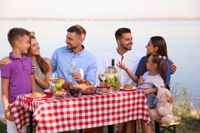 Happy families with little children at picnic table outdoors