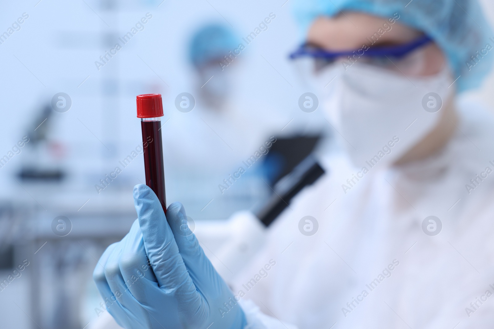 Photo of Scientist working with sample in test tube in laboratory, selective focus