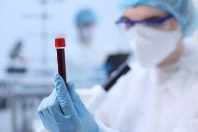 Scientist working with sample in test tube in laboratory, selective focus