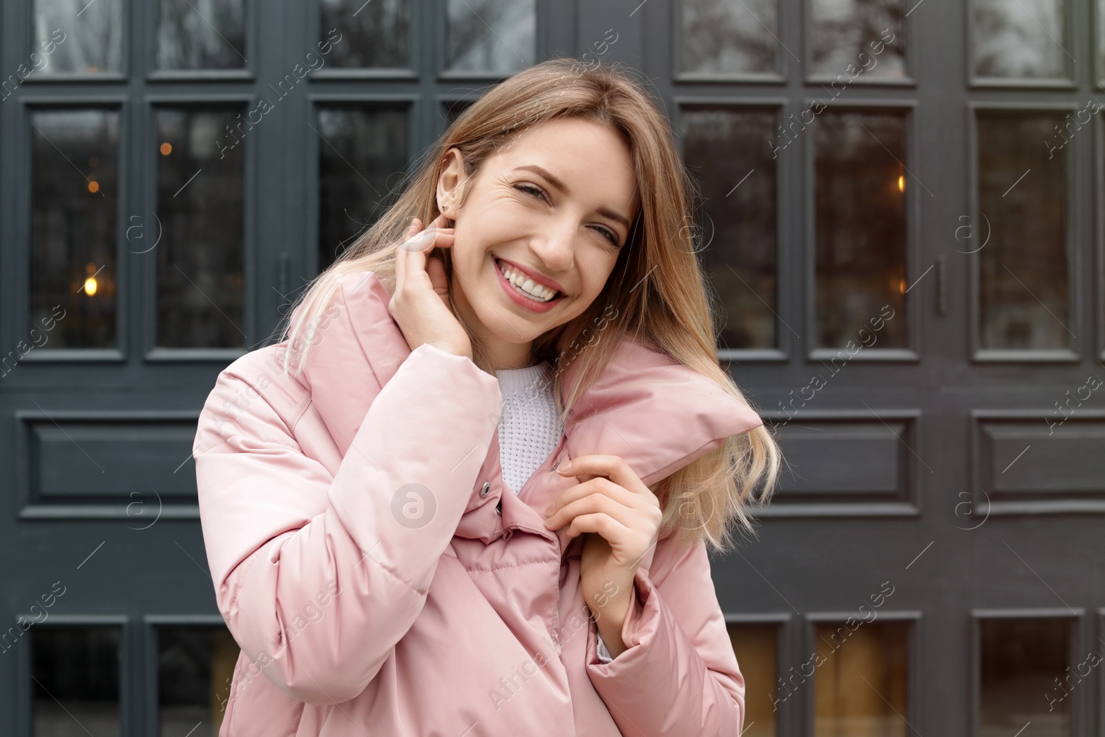 Photo of Happy young woman in warm jacket outdoors