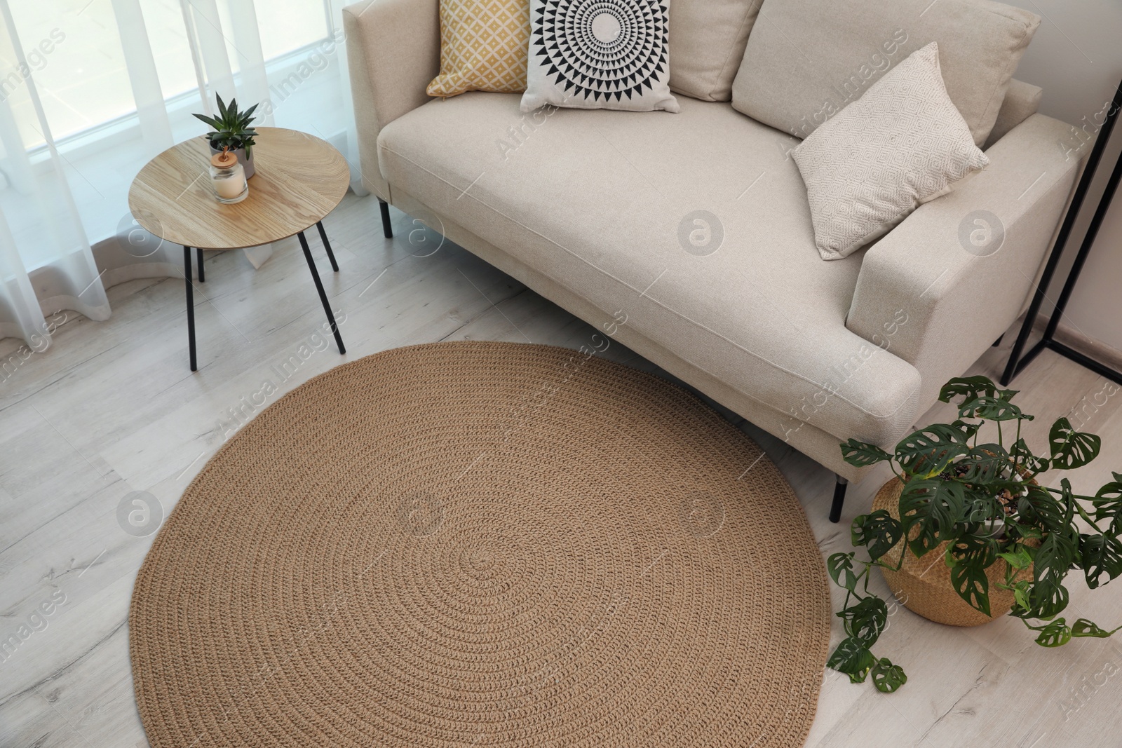 Photo of Living room interior with comfortable sofa and stylish round rug, above view