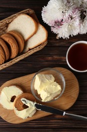 Tasty homemade butter, cookies and tea on wooden table, flat lay
