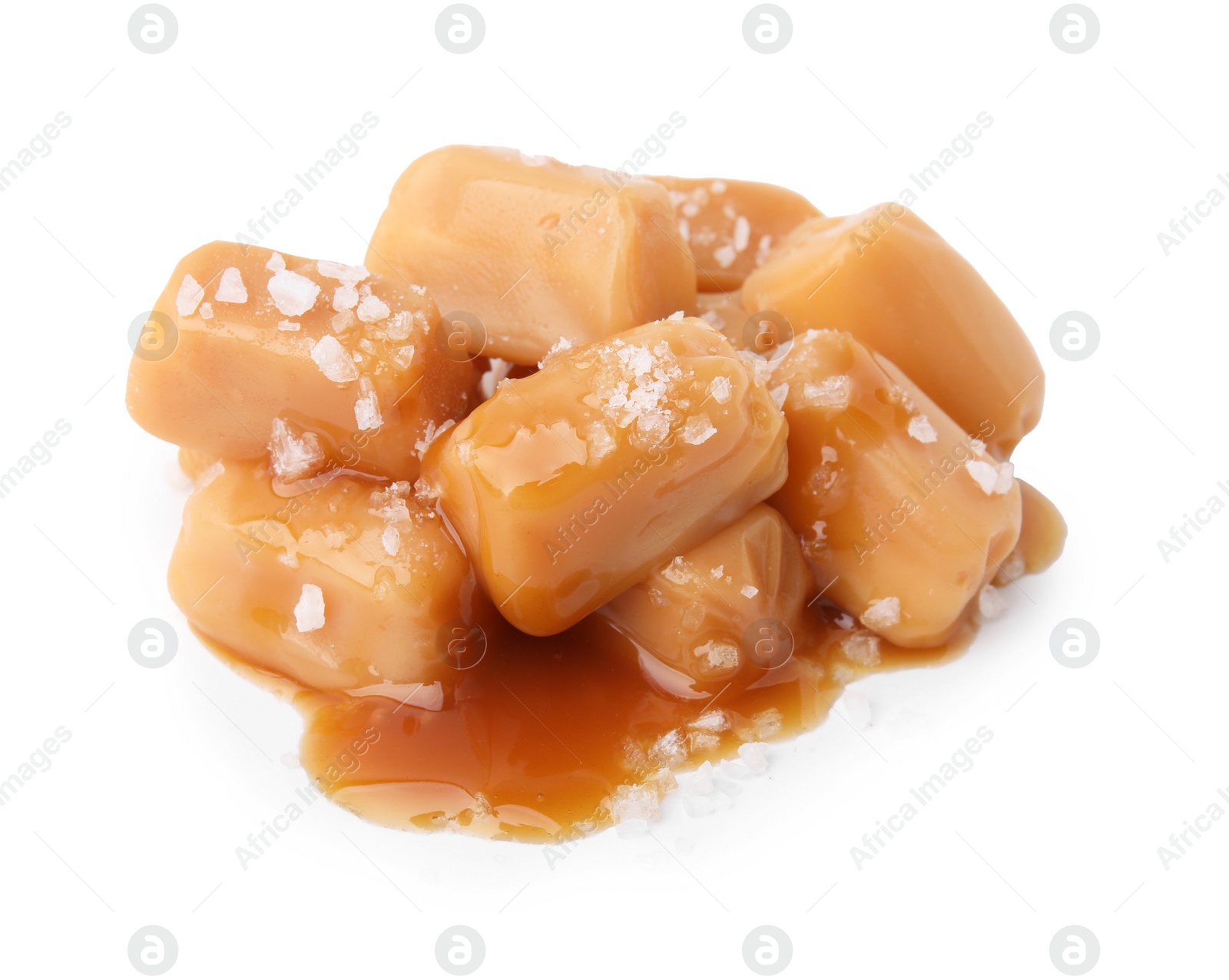 Photo of Yummy caramel candies and sea salt isolated on white