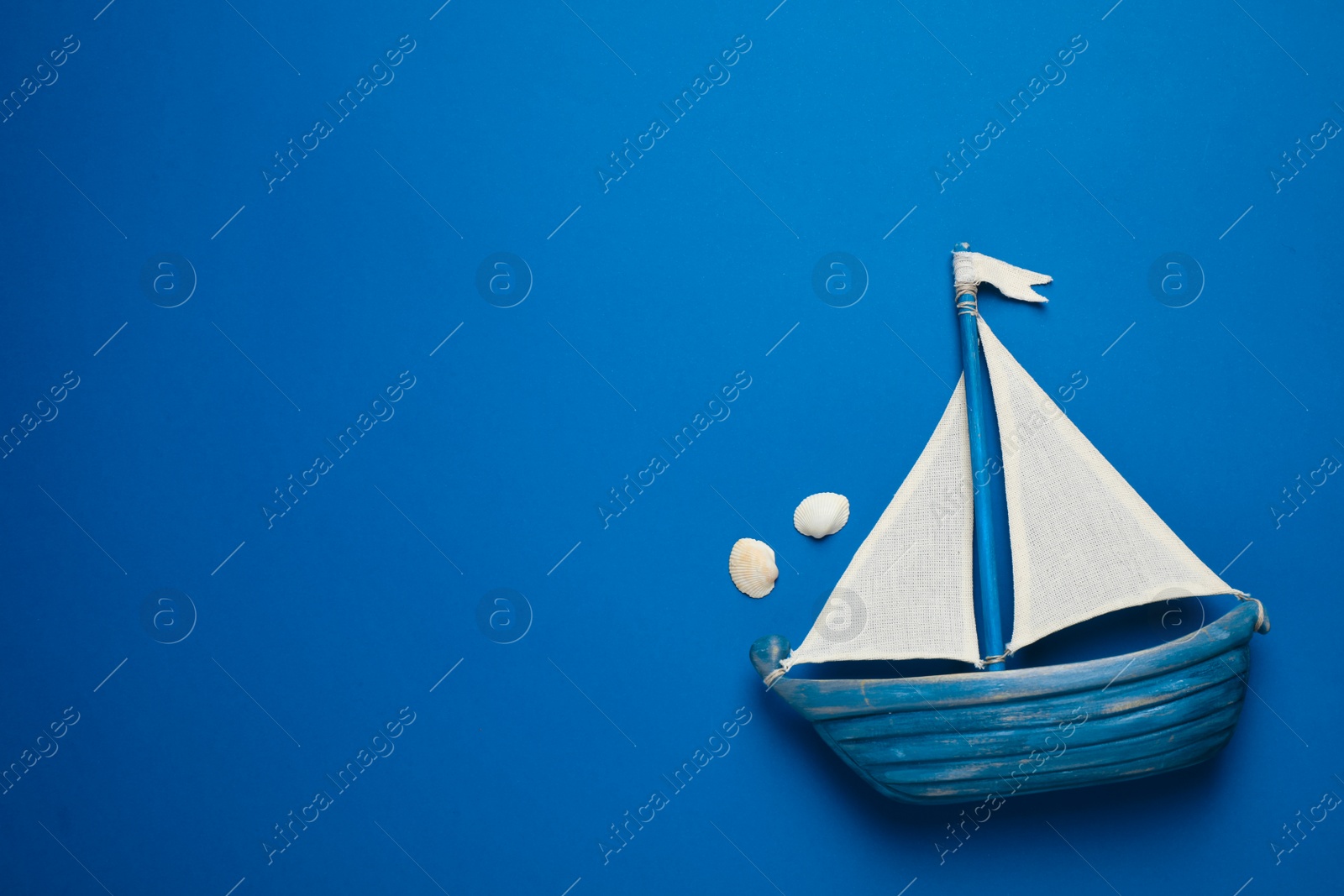 Photo of Toy ship on bright background, top view with space for text. Color of the year 2020 (Classic blue)