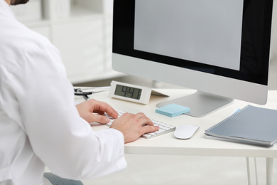 Photo of Doctor working with computer at desk in office, closeup