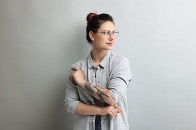 Portrait of beautiful tattooed woman on gray background