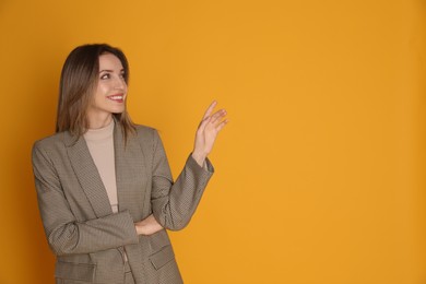 Photo of Portrait of beautiful young woman in fashionable suit on yellow background, space for text. Business attire