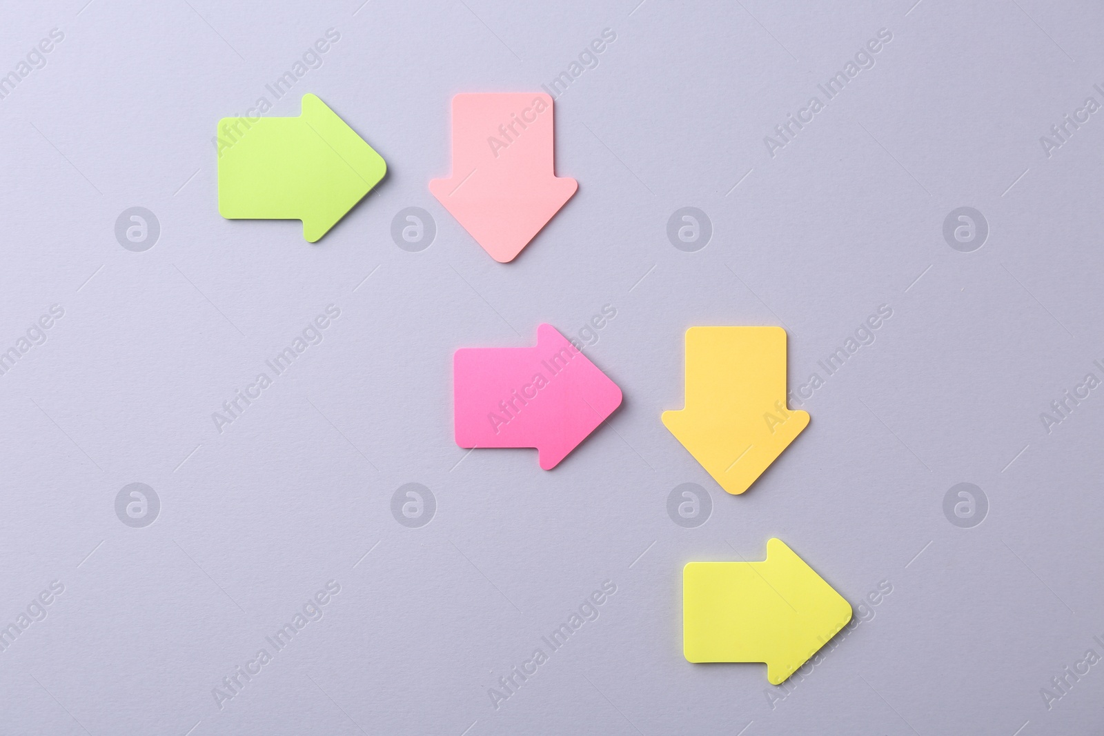 Photo of Business process organization and optimization. Scheme with arrow shaped paper notes on grey background, top view