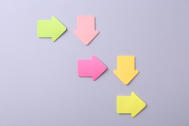 Photo of Business process organization and optimization. Scheme with arrow shaped paper notes on grey background, top view