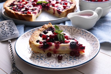 Photo of Piece of delicious currant pie served on white wooden table