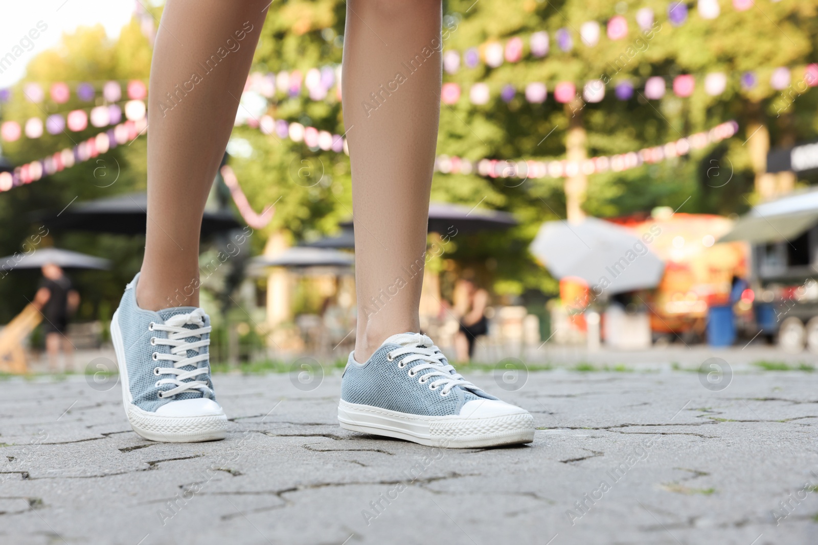 Photo of Woman in stylish shoes walking on city street, closeup