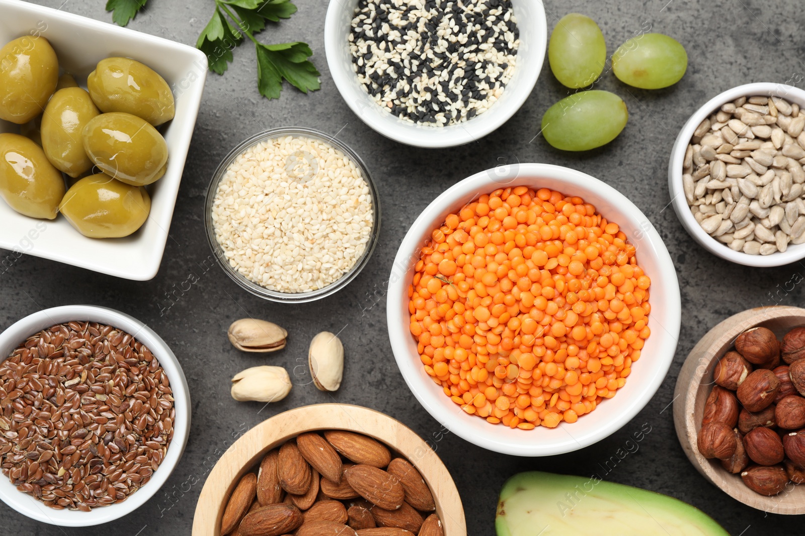 Photo of Different products high in natural fats on grey table, flat lay