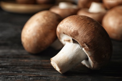 Fresh champignon mushrooms on wooden table, closeup. Space for text