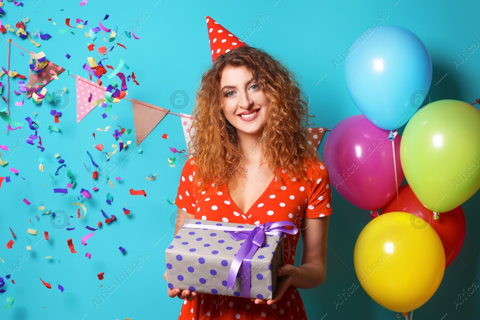 Photo of Young woman with birthday gift on color background