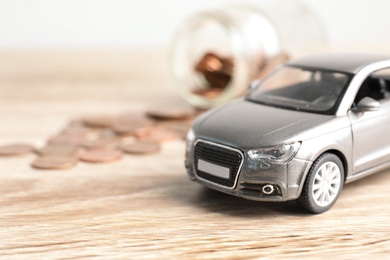 Photo of Toy car and money on table, space for text. Vehicle insurance