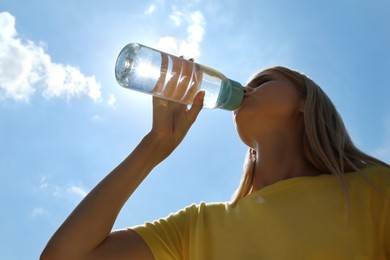 Photo of Woman drinking water to prevent heat stroke outdoors