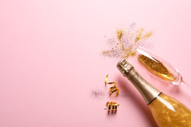 Flat lay composition with bottle of champagne for celebration on pink background. Space for text