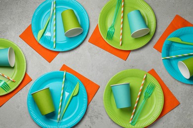 Photo of Flat lay composition with disposable tableware on light background