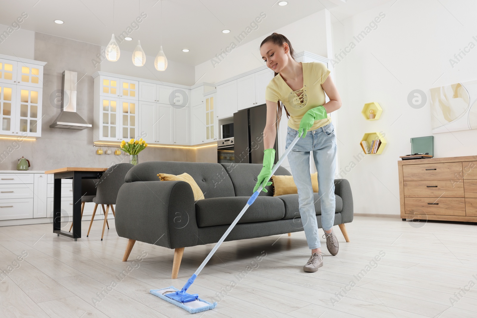 Photo of Spring cleaning. Young woman with mop washing floor at home