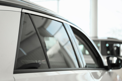 Photo of Modern car with tinting foil on window, closeup